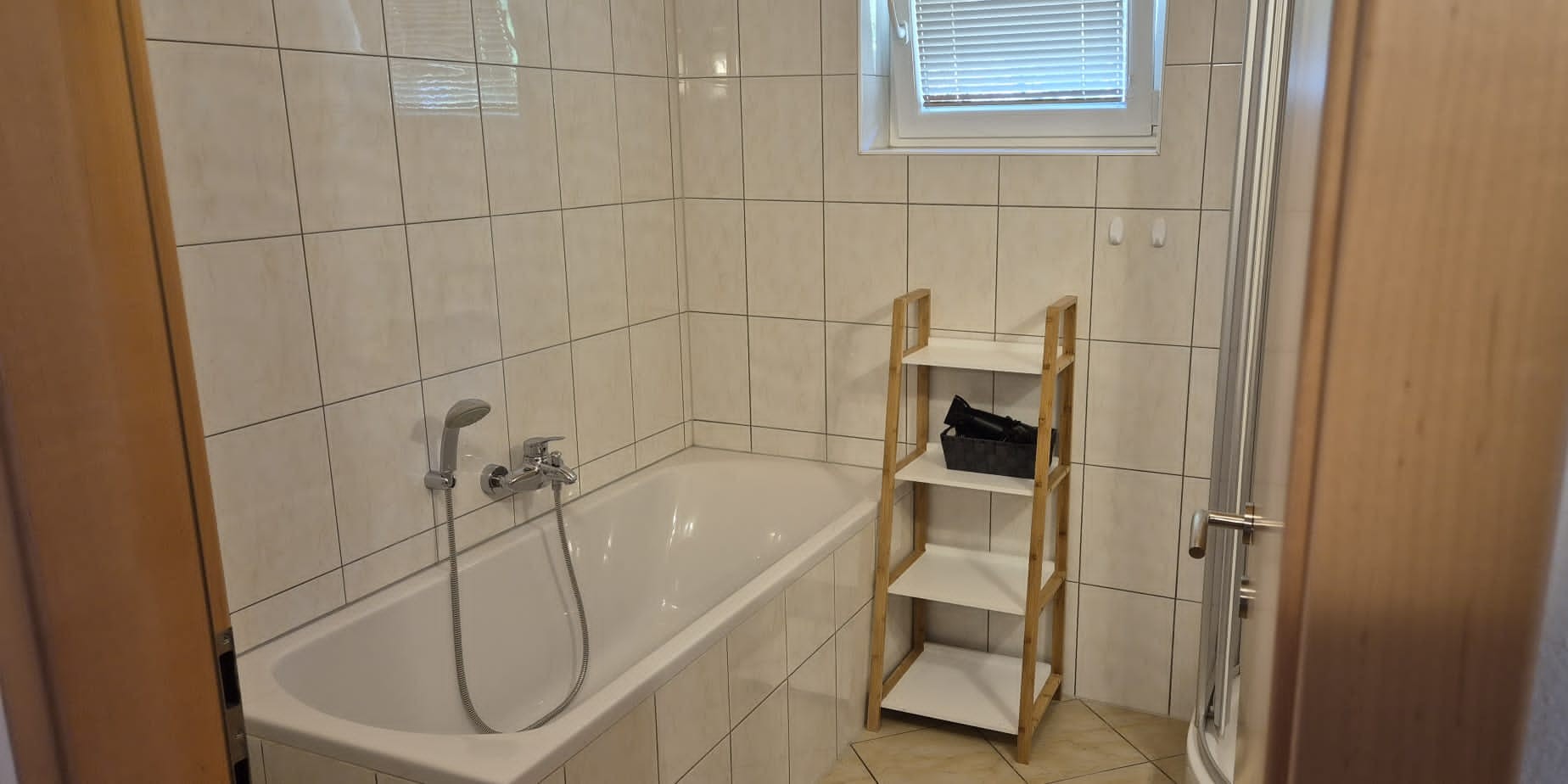 Badkamer met bad, douche en dubbele wastafel